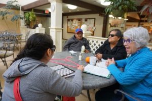 Photo of a tutor teaching English at a table to two women who are blind.