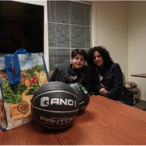 Max and his mom, Nochebuena, pose with fitness equipment and a bag of healthy groceries.